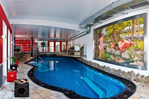 上陶恩白雪运动酒店的墙上有大画的房屋内的游泳池