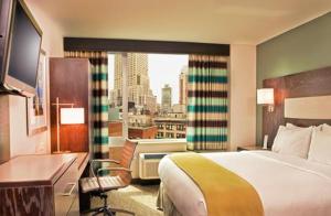 纽约时代广场南智选假日酒店的酒店客房设有一张床和一个大窗户