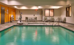 欧弗兰帕克欧弗兰帕克快捷假日套房酒店的游泳池位于带桌椅的房间