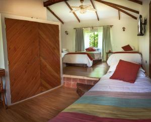 安加罗阿Pikera Uri Eco Lodge的一间卧室设有两张床和滑动谷仓门。