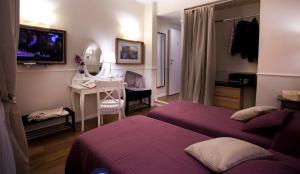 罗马Colfelice Rooms的酒店客房设有两张床、一张桌子和电视。