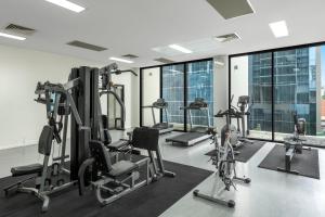 布里斯班iStay River City Brisbane的健身房设有跑步机、健身器材和窗户