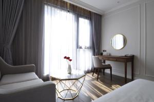 金瓯Phu Cuong Hotel Ca Mau的一间卧室配有一张床、一张书桌和一个窗户。