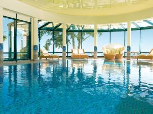 赛巴特班森班辛风情旅游度假酒店的大楼内带椅子的大型游泳池