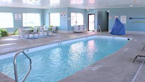 普莱恩维尤普莱恩维尔智选假日酒店的一个带桌椅的大型游泳池