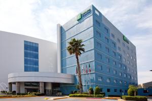 圣路易斯波托西Holiday Inn Express San Luis Potosí, an IHG Hotel的前面有棕榈树的建筑