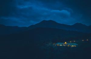 乌提Destiny - The Farm Resort的享有山间房屋的夜景
