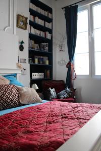 欧苏瓦地区瑟米Le Boudoir d'artiste的一间卧室设有一张红色大床和窗户