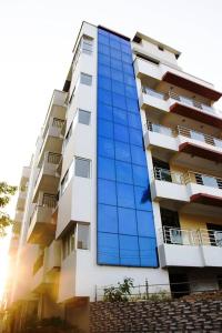 古瓦哈提Hotel Park Riviera的一座高高的建筑,上面有蓝色的玻璃窗