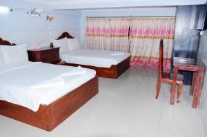 金边Khmer Village Guesthouse的一间卧室配有两张床、一张桌子和一把椅子