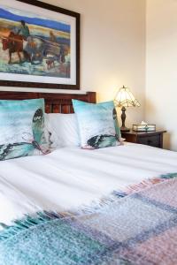 西蒙镇月光宾馆的一张带白色床单和蓝色枕头的床
