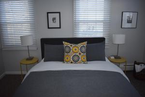 斯托The Little River Inn的一间卧室配有一张带两张桌子和两盏灯的床。
