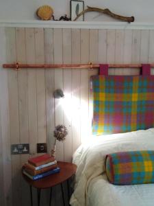 邓韦根Blas Rooms的一间卧室配有一张床和一张桌子及书籍