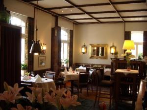 埃姆斯代滕林登霍夫酒店的餐厅设有桌椅和镜子