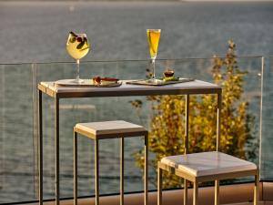阿凯松爱奥尼亚山酒店 的一张桌子和两把椅子,上面有一杯葡萄酒