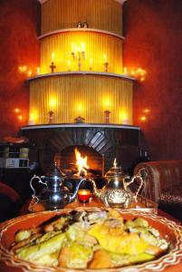 斯库拉Dar Calme Chez El Bouhali的餐桌上的一盘食物,壁炉