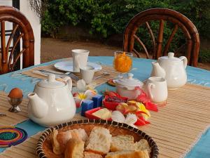 阿姆巴托洛阿卡Villa Malandy Appart Hôtel Duplex 1的一张桌子,上面有蓝桌布,上面有面包和茶壶