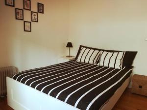 里斯本Lovely Apartment near Belém的一张带黑白条纹枕头的床