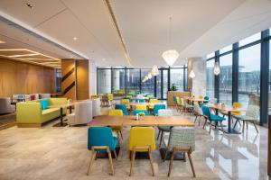无锡无锡太湖新城智选假日酒店的餐厅设有桌椅和窗户。