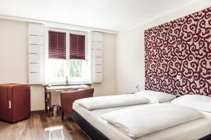 格拉茨Hotel Weitzer Graz - Centre of Graz的一间卧室设有两张床和红色及白色的墙壁