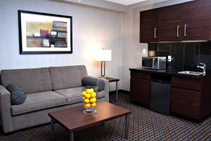 彭布罗克彭布罗克智选假日酒店的一间客厅,客厅配有沙发和一张桌子,位于酒店的房间