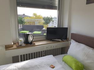 杜塞尔多夫Studiotel TOP LOFT的一间卧室设有一张床和一个带电视的窗户。