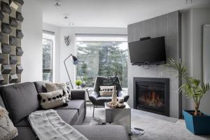 惠斯勒The Modern Whistler Apartment - Ski-in ski-out的带沙发和壁炉的客厅