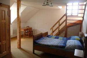 Chmelovice克梅尔维奇农场旅馆的一间卧室设有一张床和一个楼梯