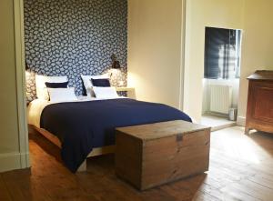 CaucalièresChambres d'hôtes du Domaine de Bonnery的一间卧室配有一张大床和蓝色图案的墙壁