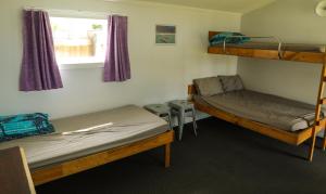 玛拉豪Marahau Beach Camp的客房设有两张双层床和一扇窗户。