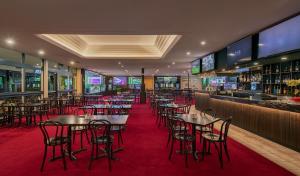 悉尼Palms Hotel的一间带桌椅的餐厅和一间酒吧