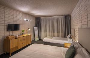 悉尼Palms Hotel的酒店客房设有两张床和一台平面电视。