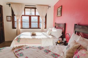 TlatlauquitepecHotel San Jorge的配有粉红色墙壁和窗户的客房内的两张床