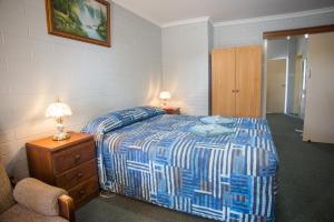 墨累桥穆雷桥汽车旅馆的一间卧室配有一张带蓝色和白色棉被的床
