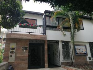 麦德林apartamentos casa Margarita en laureles estadio su hogar en Medellin的前面有棕榈树的房子