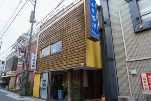 Saikiゲストハウス さんかくワサビ的街道上拥有木外墙的建筑