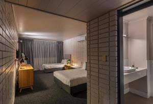 悉尼Palms Hotel的酒店客房设有两张床和盥洗盆