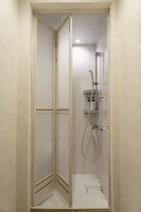 Saikiゲストハウス さんかくワサビ的浴室里设有玻璃门淋浴