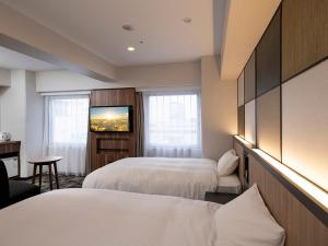 高崎高崎华盛顿广场酒店的酒店客房设有两张床和一台平面电视。
