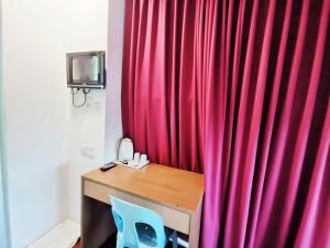 古晋Homestay Kuching Hotel的一张带蓝色椅子的桌子旁的红色窗帘