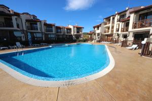 阳光海滩梅纳德御岭山庄酒店的一座大型蓝色游泳池,位于部分建筑前