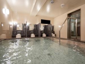 仓敷Green Rich Hotel Kurashiki Ekimae (Artificial hot spring Futamata Yunohana)的游泳池位于酒店客房内,设有浴缸