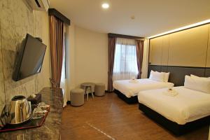 美塞Orasa hotel的酒店客房设有两张床和一台平面电视。