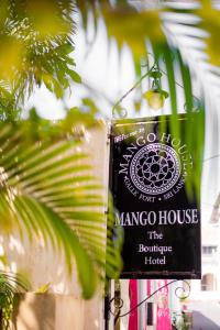高尔Mango House - Galle Fort的棕榈树旁红树林房屋的标志