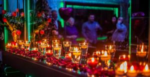 陶格夫匹尔斯Biplan City的一张桌子,上面放着蜡烛和红色的花朵和人