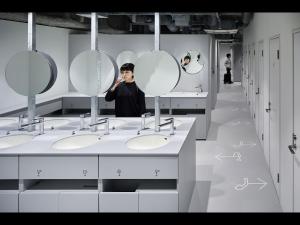 东京9h nine hours Suidobashi的站在带水槽和镜子的浴室中的男人