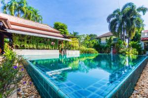 拉威海滩Monaburi Boutique Resort的房屋前的游泳池