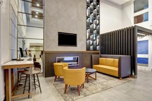 惠特比惠特比奥沙瓦智选假日酒店的大堂设有桌椅和电视。