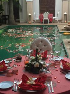 马拉喀什雷亚德夏玛套房酒店及Spa的一张桌子,上面有红色的桌布和水池