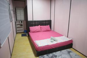 巴东勿刹Padang Besar Red Cabin Homestay的小卧室配有粉红色的床和泰迪熊